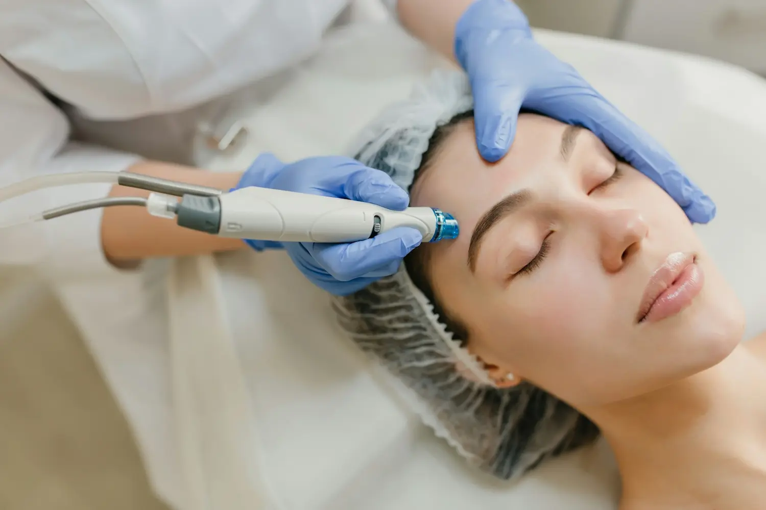 facial aesthetics treatment on a female lying down with her eyes closed